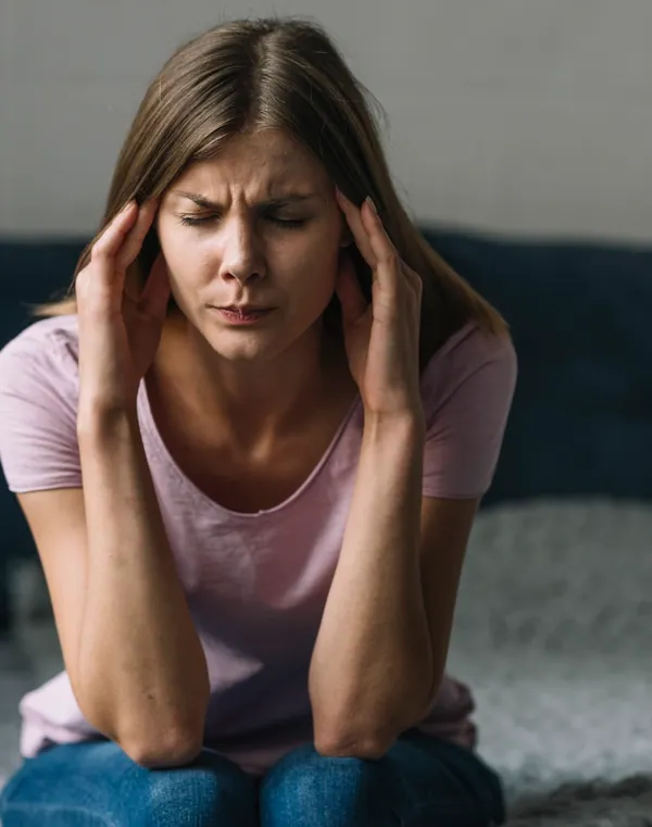 Woman holding her head with a migraine