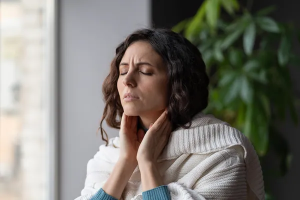 Woman holding her painful neck