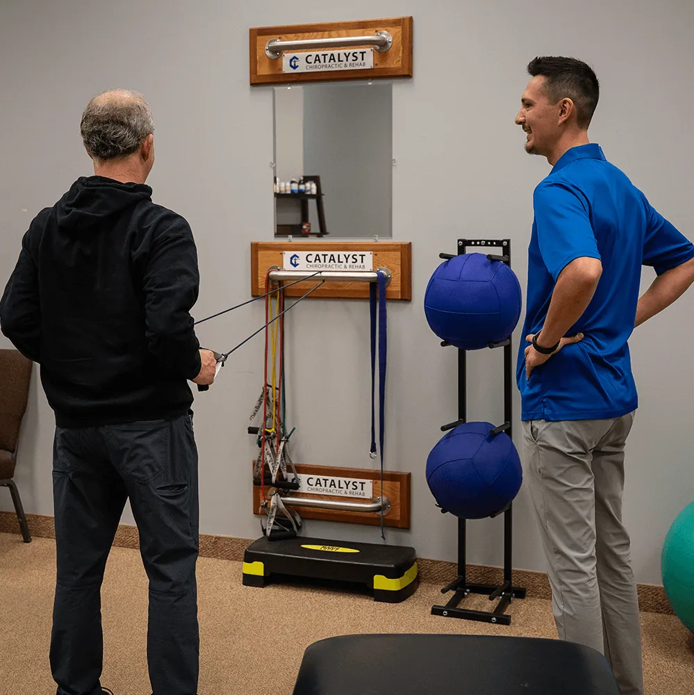 Patient doing rehab exercises with coaching at Catalyst Chiropractic and Rehab