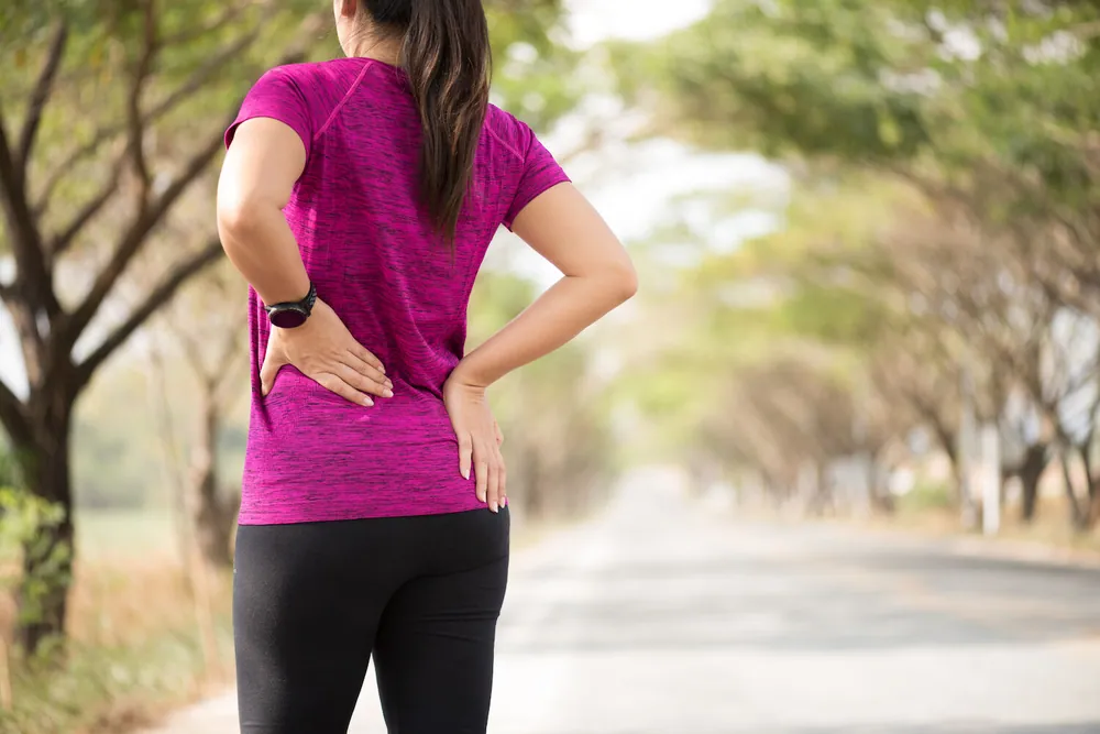 Exercising woman with back pain, Herniated Disc Treatment in Blaine, MN