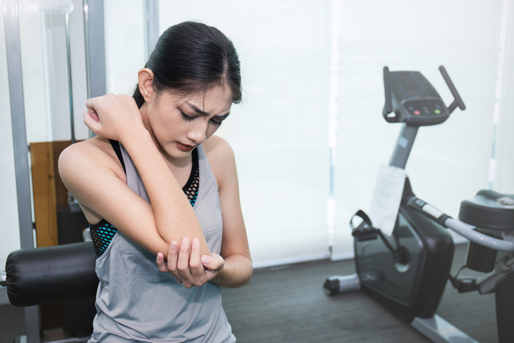 young woman experienced arm pain while exercising