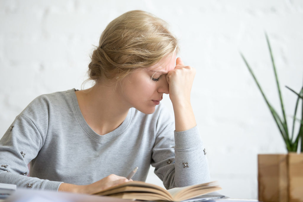 blonde woman suffer from vertigo while reading a book