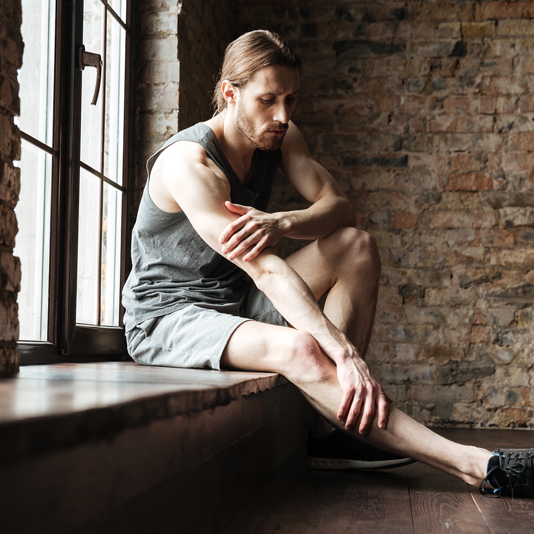 athlete man holding leg due to pain