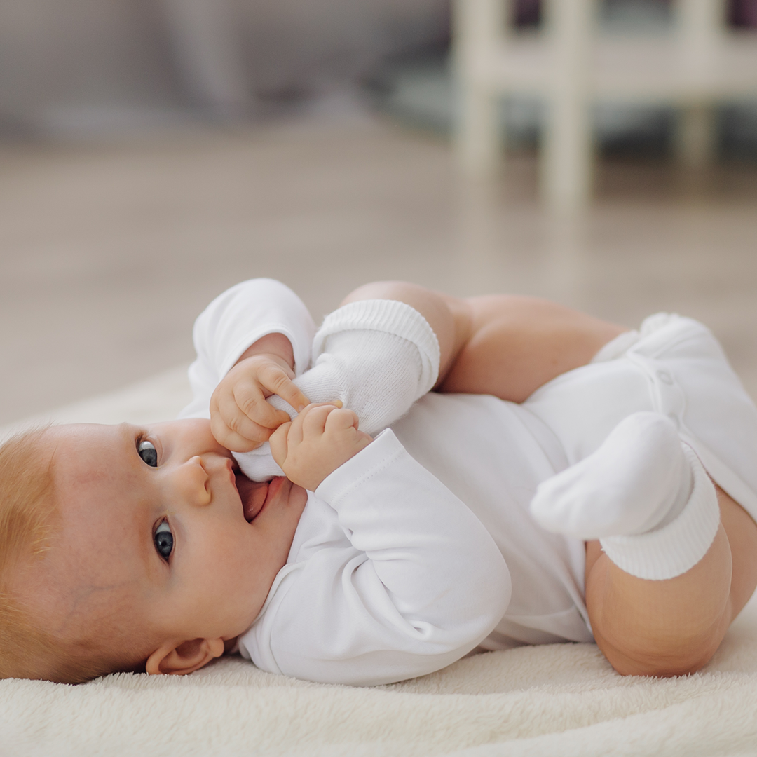 pediatric care chiropractor, baby lying in fur carpet playing his foot